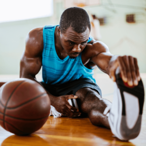 joueur de basket qui fait ses étirements à la fin de l'entrainement