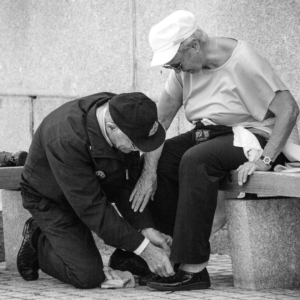 Une femme âgée assise sur un banc souffrant de douleurs aux pieds. 