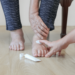 Hydrater la peau sèche des pieds de la personne âgée après les avoir laver et sécher