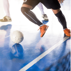 Un footballeur en salle en action portant des chaussettes de compression pour protéger ses pieds 