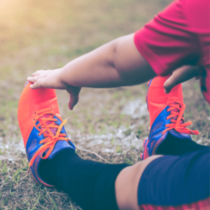 Un footballeur en plein étirements d'échauffement des pieds 