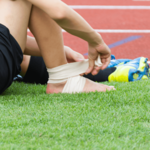 Un footballeur se fait un bandage de la cheville sur le terrain de foot à la suite d'une entorse