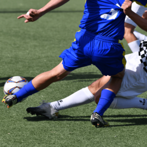 Footballeurs en pleine action exposant leurs pieds à de possibles chocs et douleurs