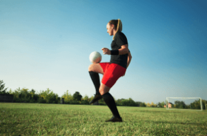 Une joueuse de football en plein jonglage : le pied plat dans le foot, tout ce qu'il faut savoir